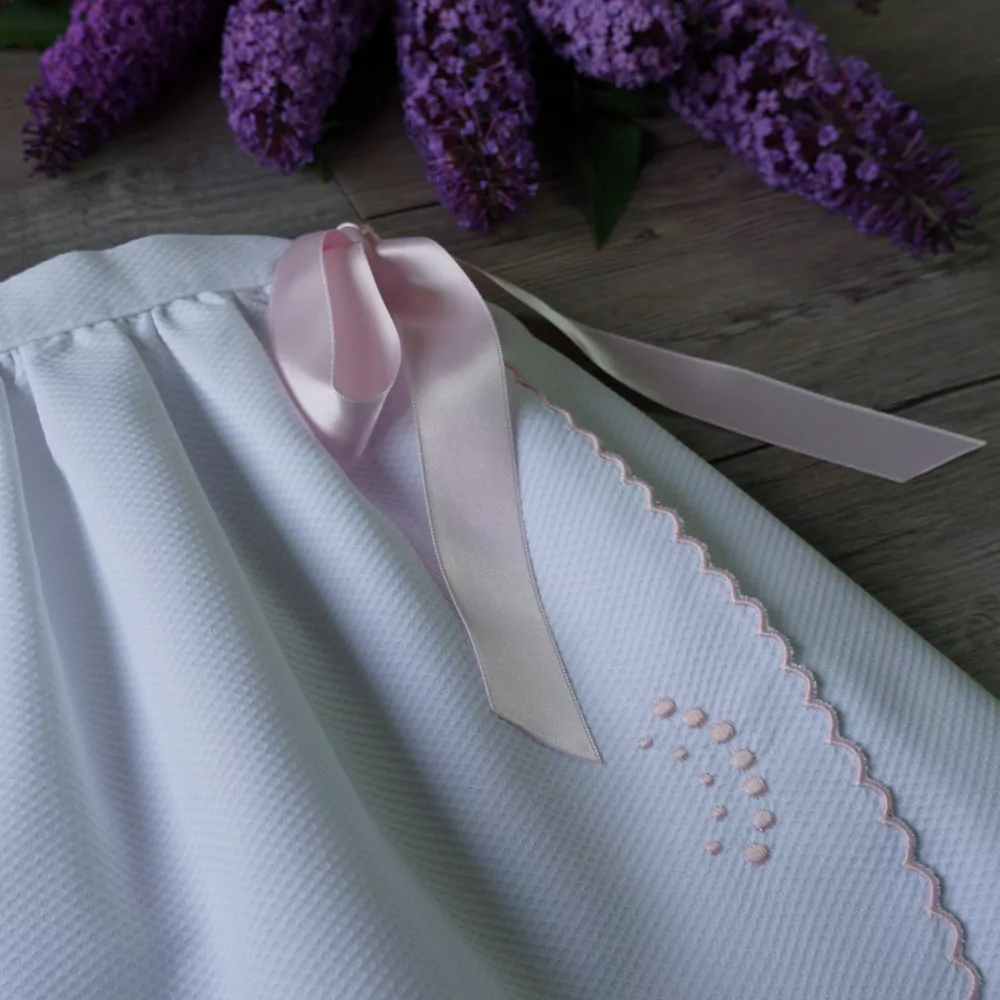 Detalle faldón festoneado blanco y rosa
