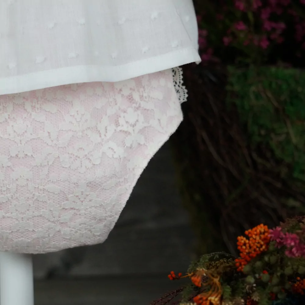 Detalle conjunto blusa y cubrepañal rosa