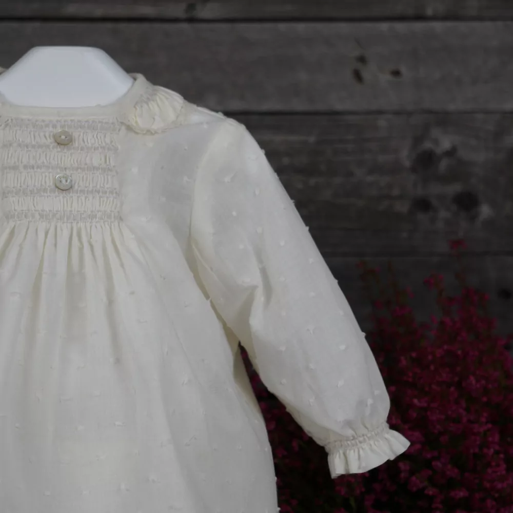 Detalle conjunto blusa y cubrepañal marfil